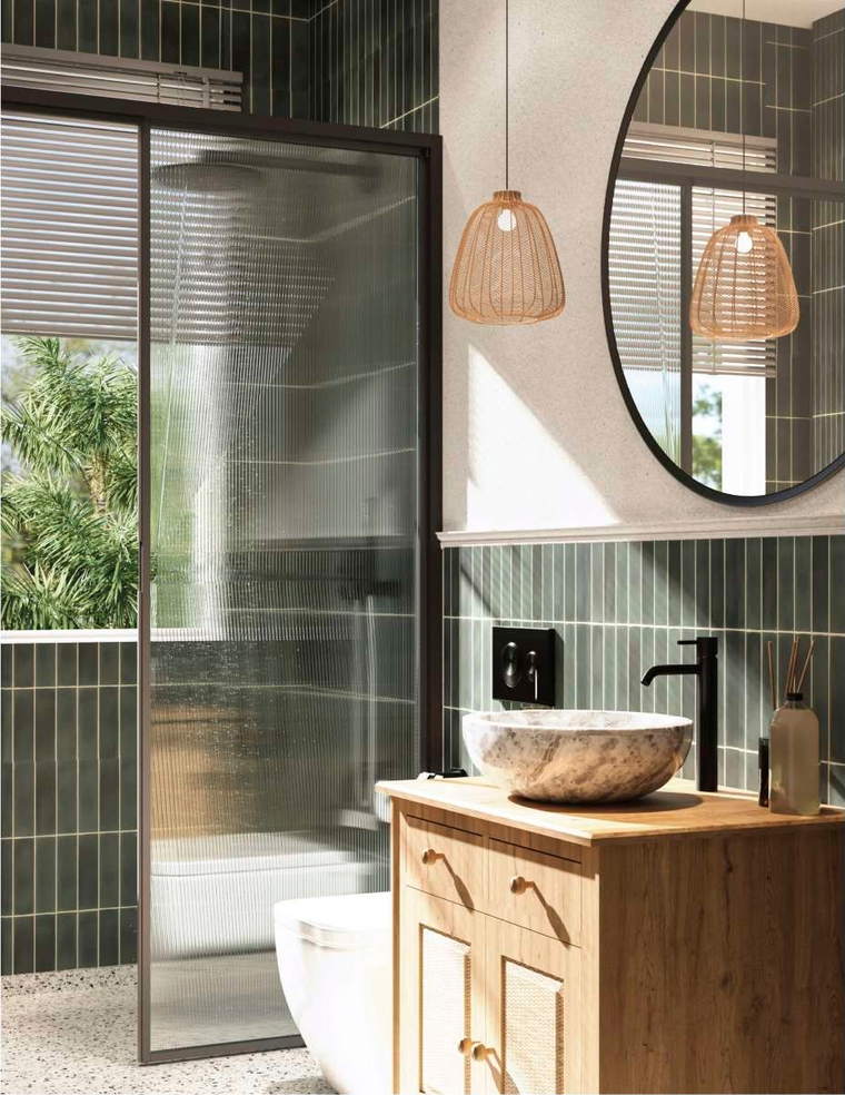 Bathroom in dark green stacked tile with a stone vessel basin on a wooden vanity and a glass-partitioned wet area