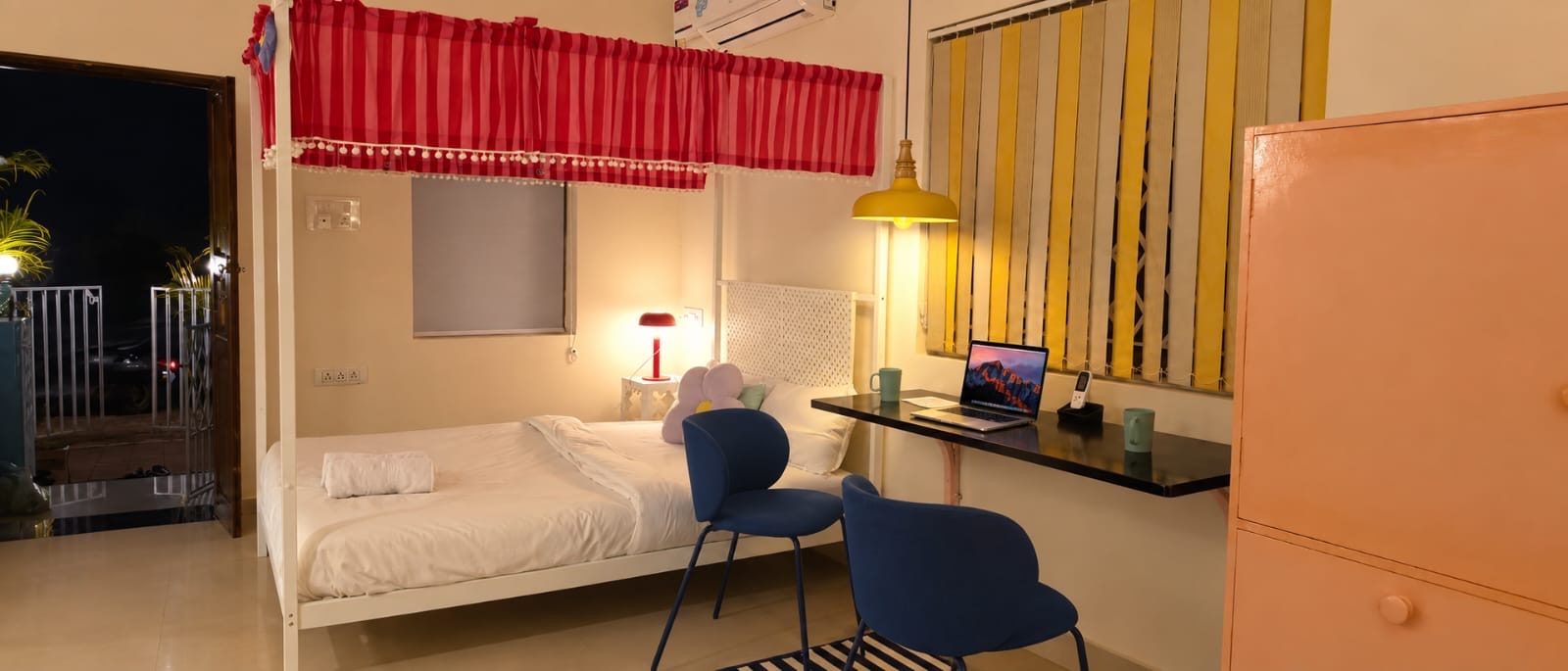 The studio at night, with the four-poster bed, the desk and its door open to the landing outside